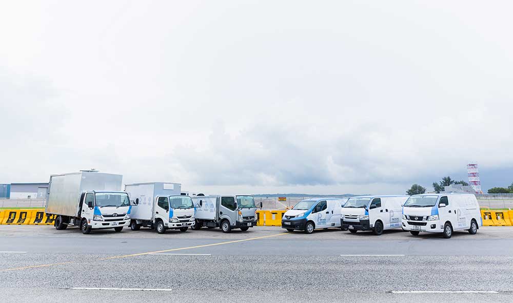 Three lorries and three vans that are part of Pan Pacific Leasing’s commercial vehicle rental fleet in Singapore, parked at the road 