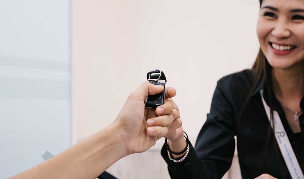 A staff member from Pan Pacific Leasing, a commercial vehicle rental company in Singapore handing over the car key